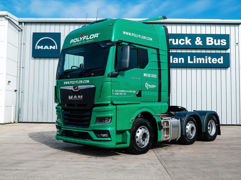 Front three-quarter view of a green MAN TGX tractor unit in Polyflor livery supplied by Steadplan